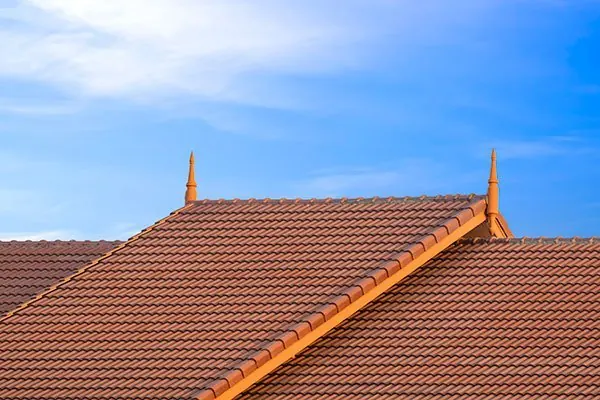 Tile and steel roofing work on a house roof